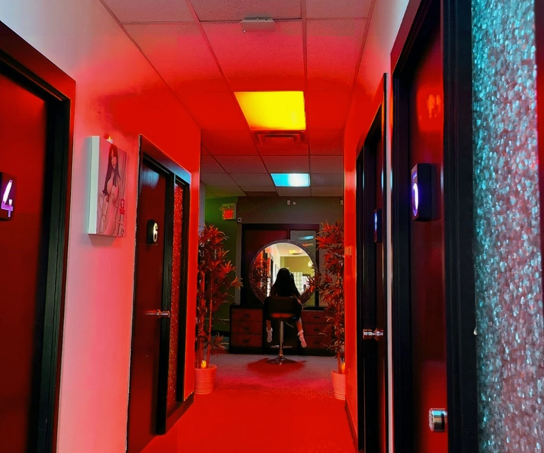 Hallway of Oh My Doll adult spa in Edmonton, Alberta, Canada with vibrant red and blue lighting.